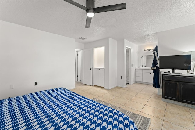 bedroom featuring light tile patterned floors, a ceiling fan, visible vents, and a textured ceiling