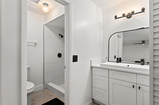 full bathroom with vanity, tile patterned flooring, a shower stall, a textured ceiling, and toilet