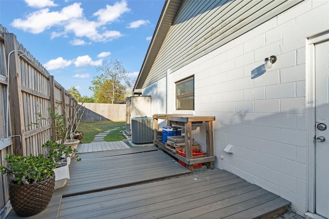 wooden terrace featuring cooling unit and a fenced backyard