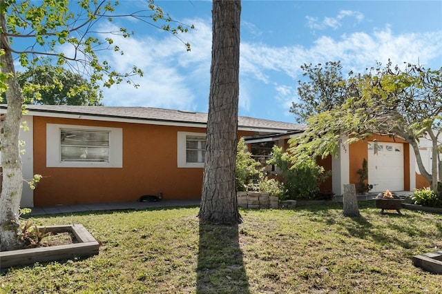 view of side of home featuring a yard, a fire pit, and stucco siding