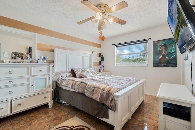 bedroom with a ceiling fan and a textured ceiling