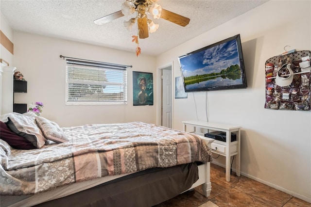 tiled bedroom with baseboards, a textured ceiling, and a ceiling fan