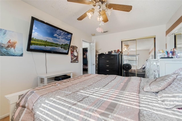 bedroom with a closet, a textured ceiling, and a ceiling fan