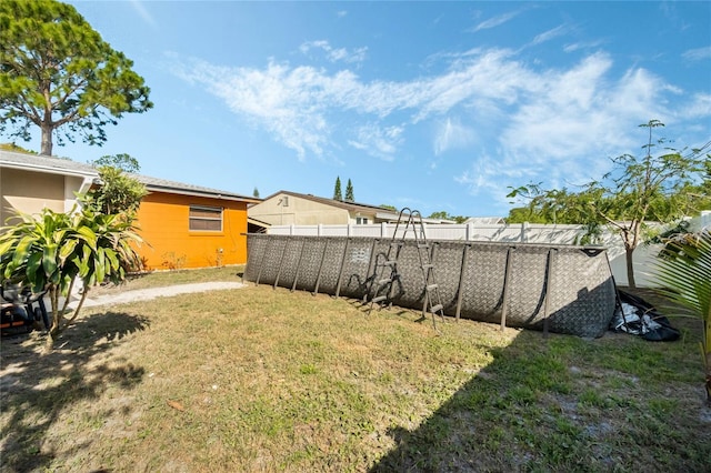 view of yard with a swimming pool and fence