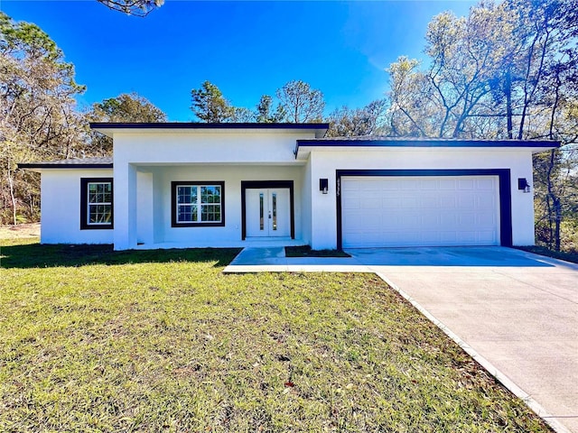 ranch-style home featuring stucco siding, french doors, concrete driveway, a front yard, and a garage