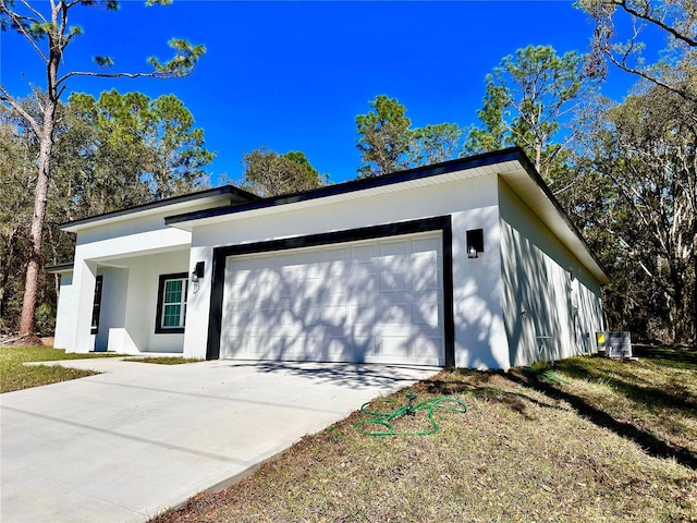 view of front of property featuring stucco siding, concrete driveway, and an attached garage