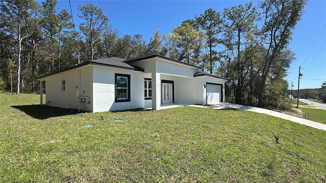 view of front facade featuring stucco siding, driveway, an attached garage, and a front yard