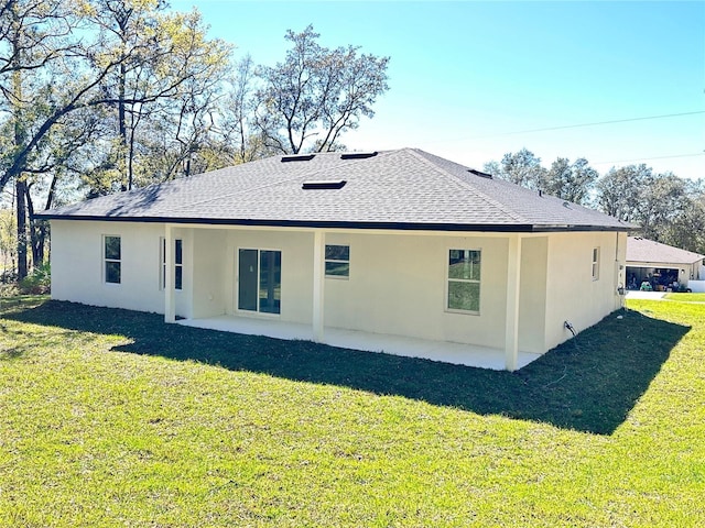 back of property featuring a shingled roof, a yard, a patio area, and stucco siding