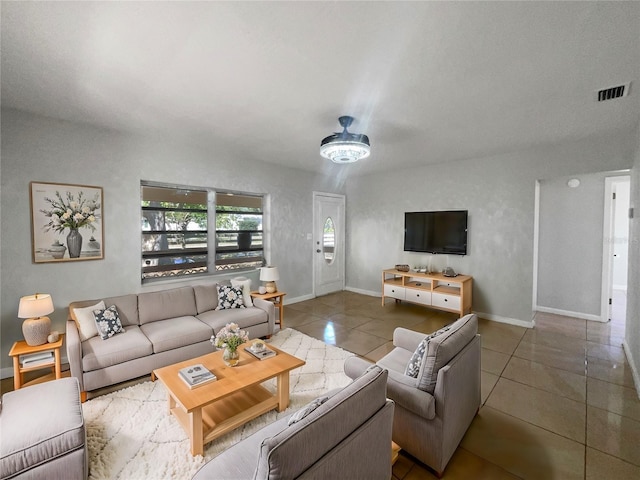 tiled living room with visible vents, baseboards, and ceiling fan