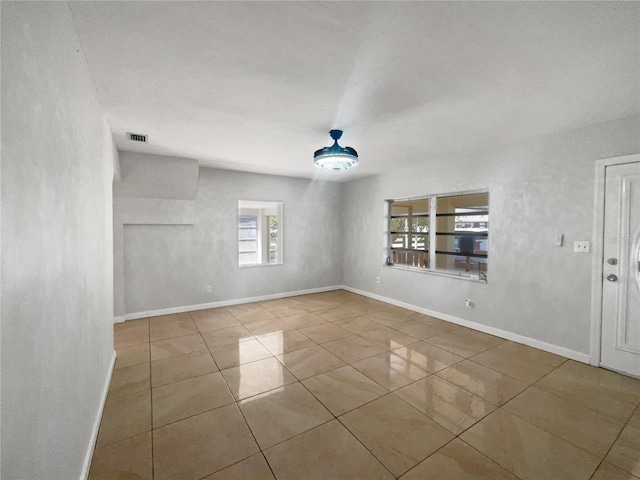 tiled empty room with visible vents and baseboards