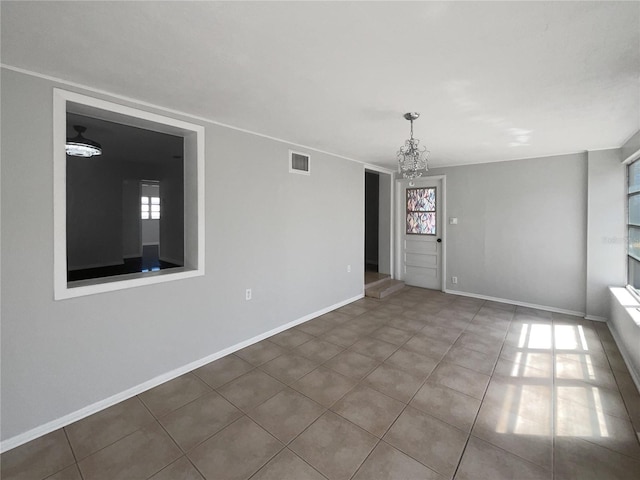 spare room featuring a healthy amount of sunlight, visible vents, and baseboards