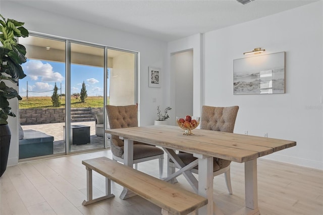 dining room with baseboards and light wood-style floors