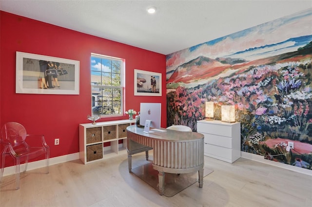 office featuring an accent wall, wood finished floors, and baseboards