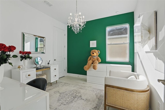 interior space featuring a notable chandelier, wood finished floors, visible vents, and baseboards