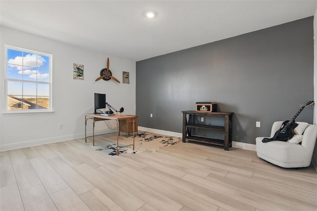 office space with baseboards and light wood-style floors