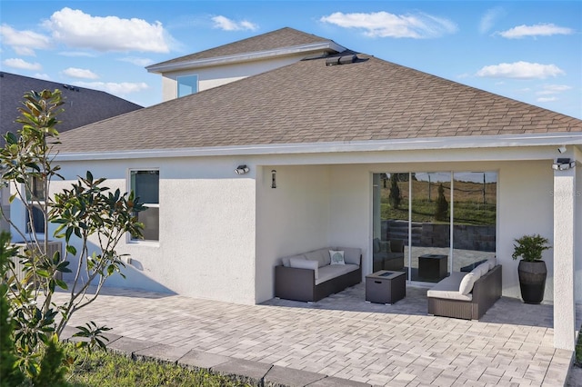 rear view of property featuring stucco siding, roof with shingles, outdoor lounge area, and a patio area