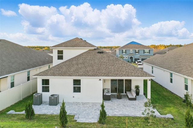 rear view of house featuring a yard, a patio area, cooling unit, and roof with shingles