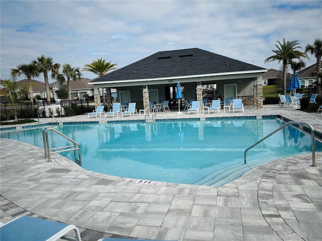 pool with a patio area and fence