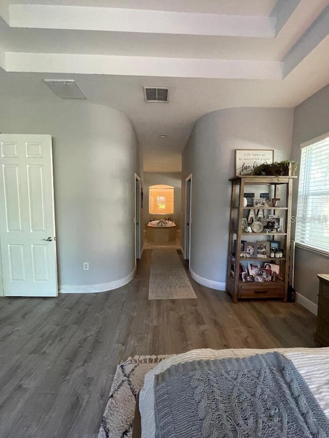 corridor featuring visible vents, baseboards, and wood finished floors