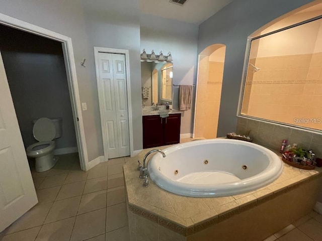 full bathroom featuring vanity, tile patterned floors, a jetted tub, and toilet