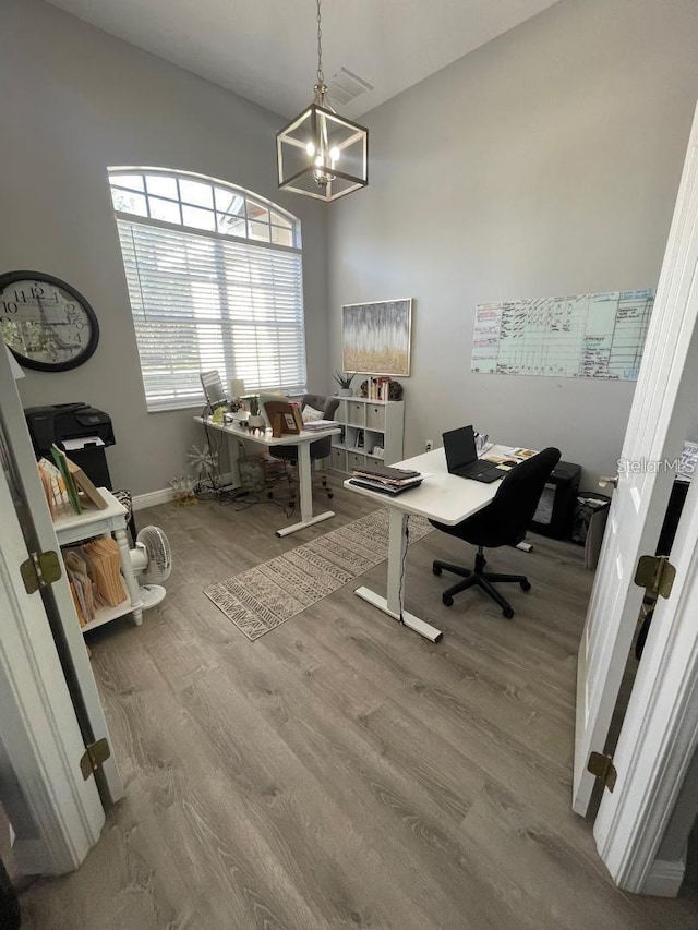 office featuring a notable chandelier, baseboards, and wood finished floors