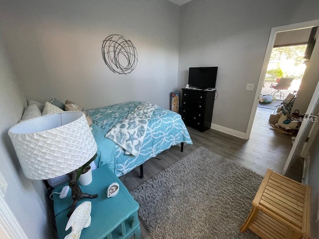 bedroom featuring baseboards and wood finished floors