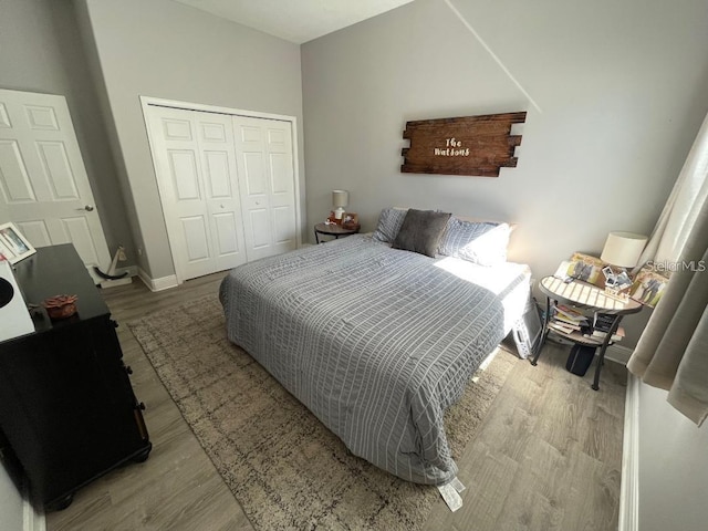 bedroom featuring a closet, baseboards, and wood finished floors