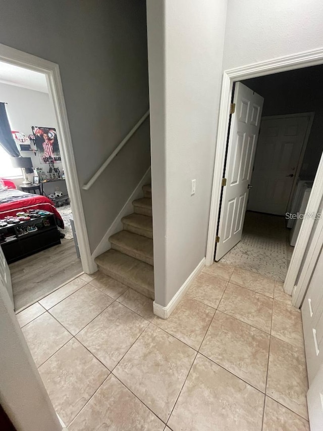 staircase featuring tile patterned flooring and baseboards