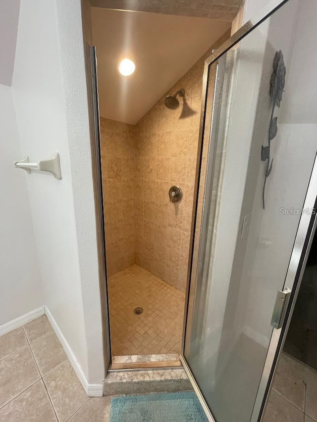 bathroom featuring baseboards, a shower stall, and tile patterned flooring