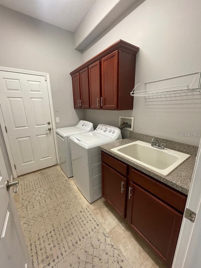 laundry room with washing machine and dryer, cabinet space, and a sink