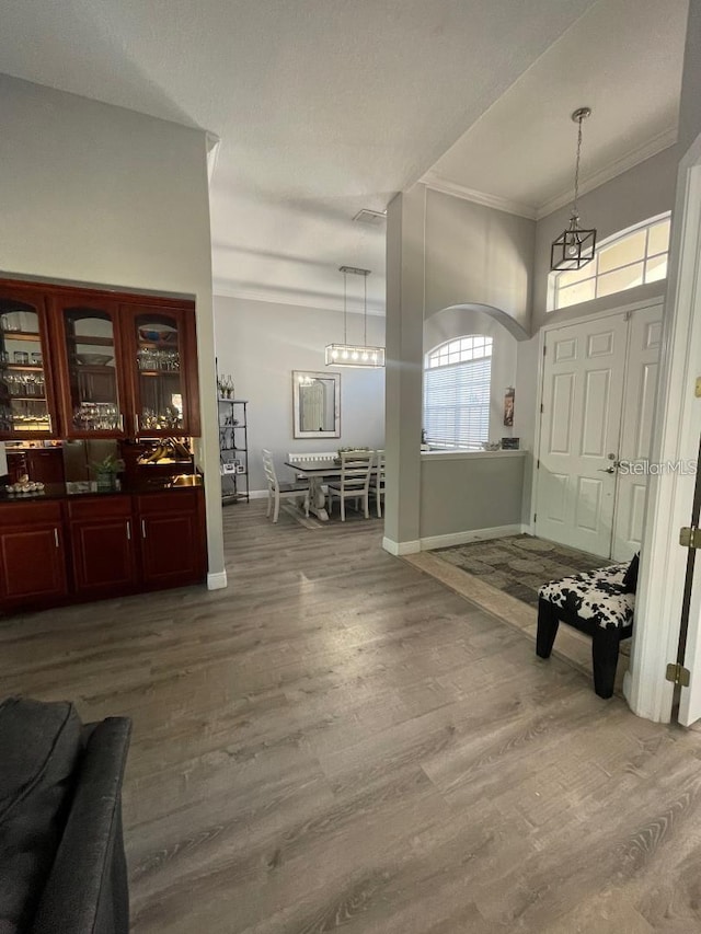 entryway with crown molding, baseboards, and wood finished floors