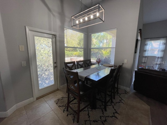 tiled dining space featuring baseboards