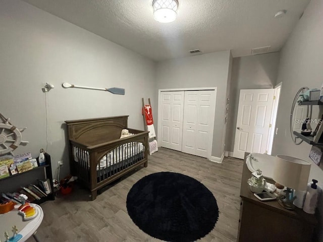 bedroom featuring wood finished floors, a closet, and a textured ceiling