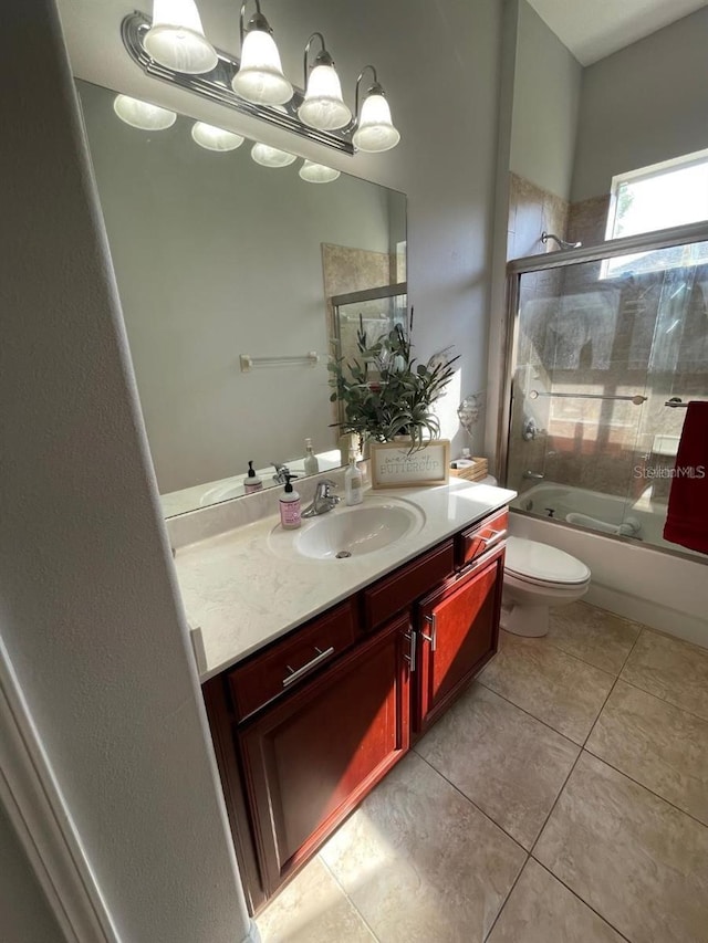 bathroom featuring vanity, tile patterned floors, toilet, and bath / shower combo with glass door