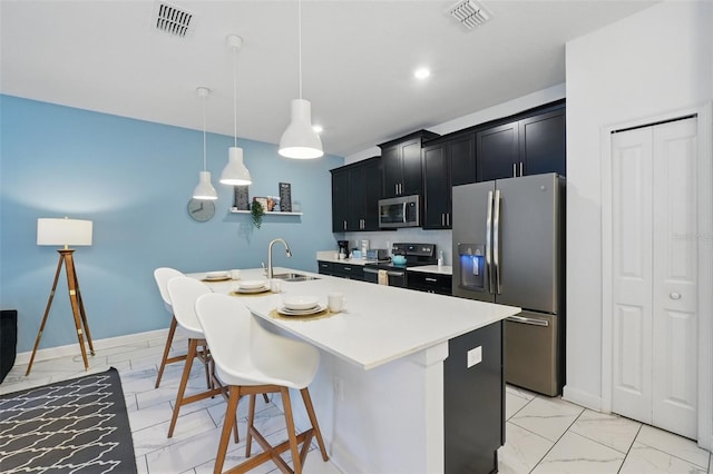 kitchen featuring a breakfast bar, a sink, stainless steel appliances, marble finish floor, and dark cabinets