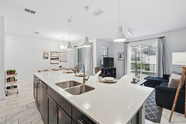 kitchen with a sink, visible vents, marble finish floor, and light countertops