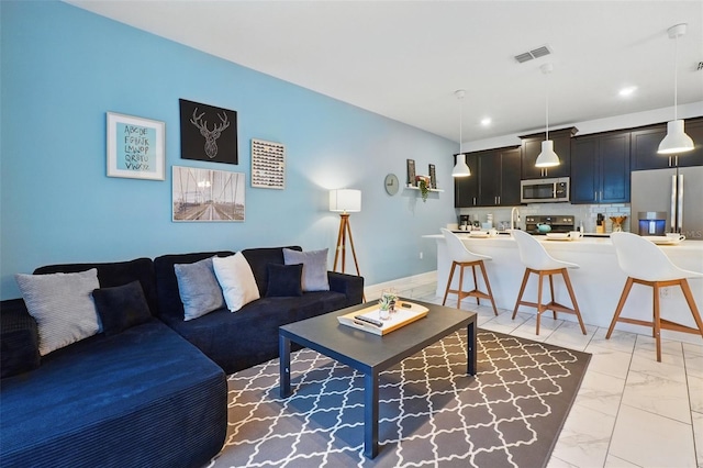 living area with recessed lighting, visible vents, and marble finish floor