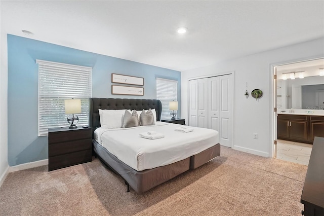 bedroom featuring multiple windows, baseboards, a closet, and light carpet