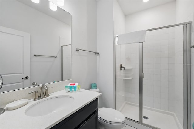 bathroom with vanity, a shower stall, and toilet