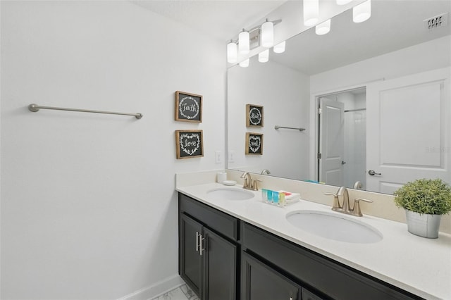 full bath featuring a sink, visible vents, baseboards, and double vanity