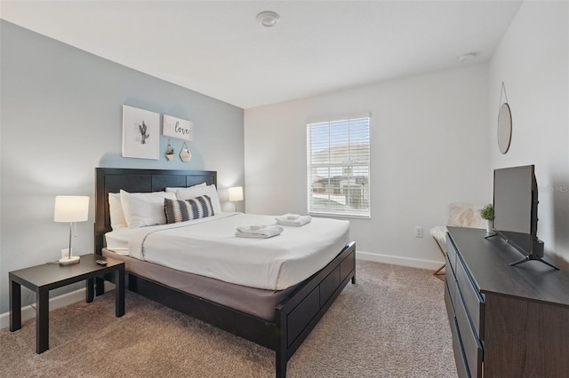 bedroom featuring baseboards and light carpet