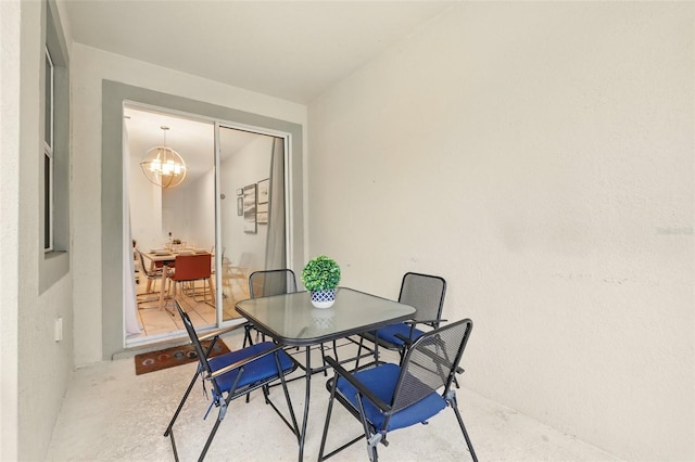 dining area featuring an inviting chandelier and concrete flooring