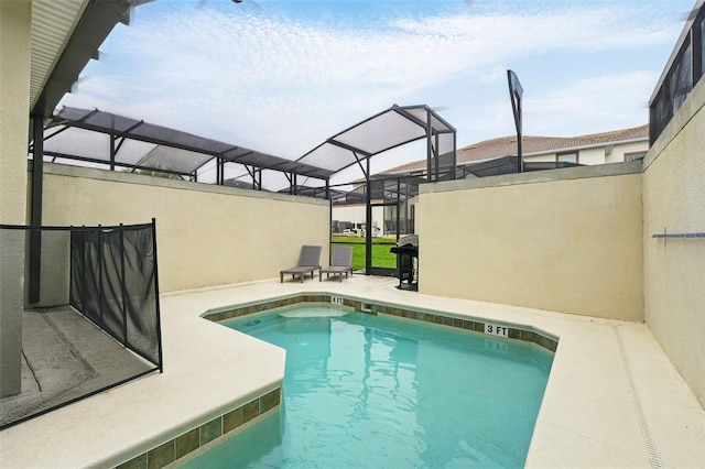 outdoor pool featuring glass enclosure and a patio