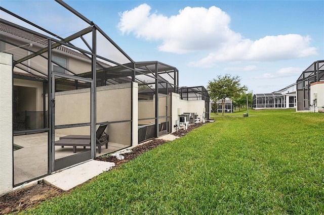 view of yard featuring glass enclosure and a patio area