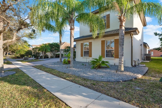 view of front of house featuring stucco siding, a front lawn, and a tiled roof