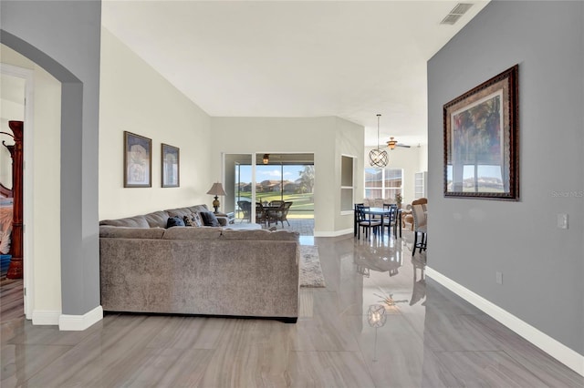 living area featuring visible vents, arched walkways, and baseboards