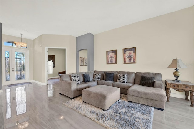 living room with baseboards and arched walkways