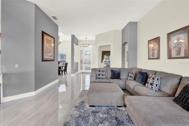 living area with visible vents, baseboards, a chandelier, arched walkways, and marble finish floor