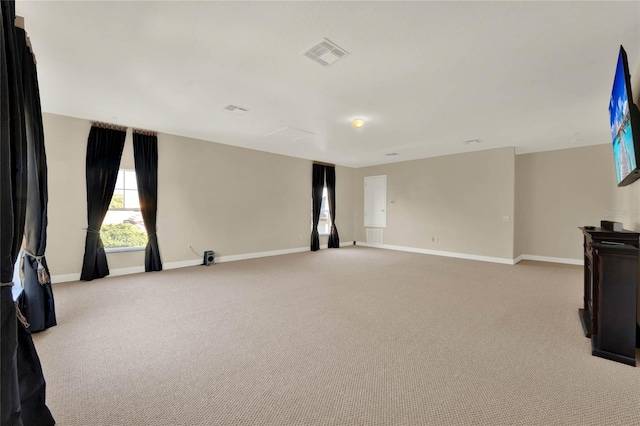 unfurnished room with visible vents, light carpet, and baseboards