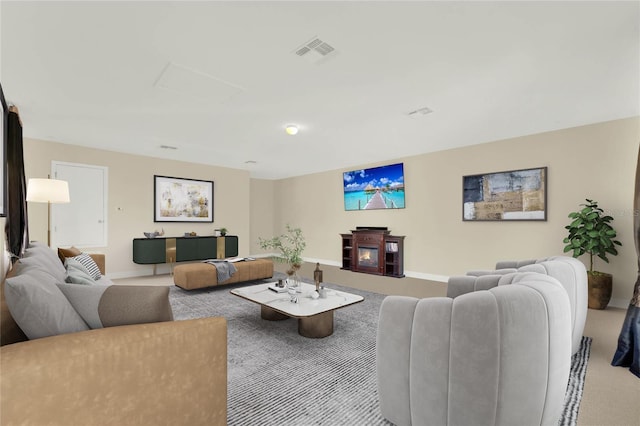 living room with visible vents, attic access, and carpet flooring